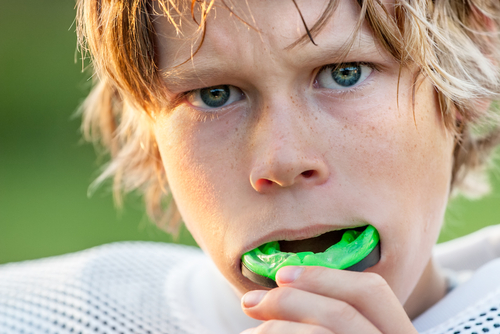 young boy putting in his mouthguard