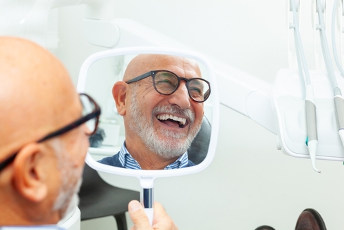 senior patient admiring his smile