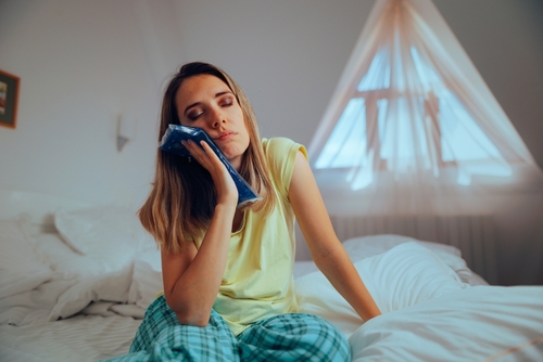 woman holding an ice pack to her jaw